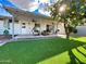 Covered patio overlooks a turf yard and a mature tree with abundant fruit at 8750 E Starlight Way, Scottsdale, AZ 85250