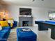 Spacious living room with accent wall, fireplace, pool table, and blue velvet furniture at 8750 E Starlight Way, Scottsdale, AZ 85250