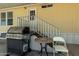 A backyard with a barbecue grill, a chair, and a small table, with stairs leading up to the back door at 8832 E Pueblo Ave # 71, Mesa, AZ 85208