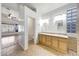 Bright bathroom featuring double sinks with wood cabinetry and decorative tile accents at 10253 E Indigo Dr, Scottsdale, AZ 85255