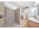 Bathroom featuring tiled shower, tile flooring, and double sink vanities at 10253 E Indigo Dr, Scottsdale, AZ 85255