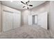 Spacious bedroom featuring neutral paint, carpet, ceiling fan, closet, and entry doors at 10253 E Indigo Dr, Scottsdale, AZ 85255