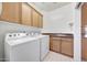 Functional laundry room with a washer, dryer, sink, and built in cabinets at 10253 E Indigo Dr, Scottsdale, AZ 85255