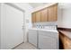 Functional laundry room with a washer, dryer, and built in cabinets at 10253 E Indigo Dr, Scottsdale, AZ 85255