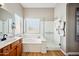 Well-lit primary bathroom features a double sink vanity, soaking tub, and a glass shower at 10591 E Morning Star Dr, Scottsdale, AZ 85255