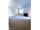 Bright living room featuring plush carpeting, a cozy fireplace, and natural light from a large window at 1075 E Chandler Blvd # 220, Chandler, AZ 85225