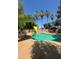 Community pool surrounded by palm trees with shade covers and a table and chairs at 1075 E Chandler Blvd # 220, Chandler, AZ 85225
