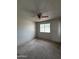A carpeted bedroom featuring a ceiling fan, window, and light walls at 11802 N 25Th Ave, Phoenix, AZ 85029