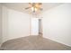 Another secondary bedroom featuring plush carpeting, neutral paint, and a ceiling fan at 11845 W Edgemont Ave, Avondale, AZ 85392