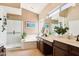 Spa-like bathroom with a soaking tub, glass-enclosed shower, and dual vanity sinks at 11861 E Becker Ln, Scottsdale, AZ 85259