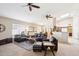 Open-concept living room with carpet, neutral paint, ceiling fans, and a view of the kitchen and dining area at 11861 E Becker Ln, Scottsdale, AZ 85259