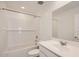 This bathroom includes a bathtub, shower combo, modern lighting, and a white vanity with sink at 12013 E Primrose Ln, Florence, AZ 85132
