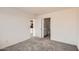 This bedroom offers neutral carpet and access to an adjacent bathroom and what appears to be a kitchen at 12013 E Primrose Ln, Florence, AZ 85132