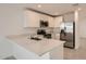 Modern kitchen featuring stainless steel appliances, white cabinets, and a breakfast bar with quartz countertops at 12013 E Primrose Ln, Florence, AZ 85132