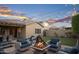 Inviting backyard patio area with outdoor seating, a fire pit, and string lights at 12152 W Briles Rd, Peoria, AZ 85383