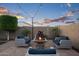Backyard featuring a fire pit surrounded by seating with charming string lights at 12152 W Briles Rd, Peoria, AZ 85383