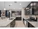 Modern kitchen featuring granite countertops, stainless steel appliances, and dark wood cabinetry at 12152 W Briles Rd, Peoria, AZ 85383