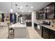 Contemporary kitchen with island seating, granite counters, and stainless steel appliances open to the living area at 12152 W Briles Rd, Peoria, AZ 85383