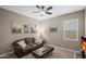 Cozy living room featuring a comfortable leather sofa, stylish coffee table, and city-themed wall art at 12152 W Briles Rd, Peoria, AZ 85383