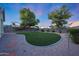 Spacious backyard featuring lush green grass, mature trees, rock landscaping and block wall fencing at 13295 N 153Rd Ln, Surprise, AZ 85379