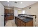 Functional kitchen with a double sink, wood cabinets, and a breakfast bar perfect for casual dining at 13295 N 153Rd Ln, Surprise, AZ 85379