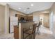 Bright kitchen featuring a breakfast bar with seating, wood cabinets, and neutral tile flooring at 13295 N 153Rd Ln, Surprise, AZ 85379