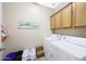 Functional laundry room with white washer and dryer, built-in cabinets, and neutral wall color at 13295 N 153Rd Ln, Surprise, AZ 85379