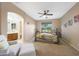Bright main bedroom boasts a ceiling fan, en-suite bathroom and comfortable seating area at 13295 N 153Rd Ln, Surprise, AZ 85379