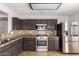 Modern kitchen with stainless steel appliances, tile floors, and granite countertops at 1356 S Mosley Ct, Chandler, AZ 85286