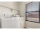 Bright laundry area with shelving and a window providing lots of natural light at 1356 S Mosley Ct, Chandler, AZ 85286