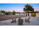 Large backyard with a patio, four chairs around a fire pit, storage shed, and desert landscaping at 13620 N 80Th Pl, Scottsdale, AZ 85260