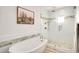 Spa-like bathroom featuring a soaking tub and glass-enclosed shower with decorative tile accents at 13620 N 80Th Pl, Scottsdale, AZ 85260