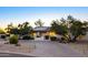 Charming single-story home with a brick driveway, mature trees, and solar panels on the roof at 13620 N 80Th Pl, Scottsdale, AZ 85260