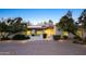 A charming single-story home with solar panels and mature landscaping, lit by warm exterior lighting at 13620 N 80Th Pl, Scottsdale, AZ 85260