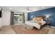 Inviting primary bedroom with a blue accent wall, wood furnishings, and access to the backyard at 13620 N 80Th Pl, Scottsdale, AZ 85260