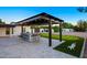 Covered outdoor kitchen and bar area with putting green and a travertine tiled patio at 13620 N 80Th Pl, Scottsdale, AZ 85260