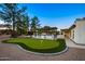 Outdoor putting green and barbecue area under a covered patio and ambient lighting at 13620 N 80Th Pl, Scottsdale, AZ 85260