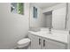 Well-lit bathroom featuring white cabinets, a modern sink, and a toilet at 1453 E South Fork Dr, Phoenix, AZ 85048