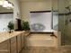 Bright and spacious bathroom featuring a soaking tub, large window, and tiled walk-in shower at 16242 S 12Th Pl, Phoenix, AZ 85048