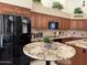 Kitchen showcasing stainless appliances, granite counters, wood cabinets, and eat-in table with stools at 16242 S 12Th Pl, Phoenix, AZ 85048