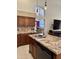Open concept kitchen with granite island, stainless sink, wood cabinets, and views into the living room at 16242 S 12Th Pl, Phoenix, AZ 85048