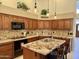 Well-lit kitchen featuring granite countertops, wood cabinets, and a stylish island with bar seating at 16242 S 12Th Pl, Phoenix, AZ 85048