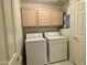 Functional laundry room with a washer, dryer, overhead cabinets, and storage space at 16242 S 12Th Pl, Phoenix, AZ 85048