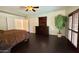 Comfortable main bedroom with hardwood flooring, dark wood dresser, and tree in the corner at 16242 S 12Th Pl, Phoenix, AZ 85048