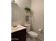 Cozy powder room with a decorative mirror, dark cabinet, and neutral-colored walls at 16242 S 12Th Pl, Phoenix, AZ 85048