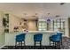Stylish kitchenette boasting white cabinetry, marble countertops, and pendant lighting over bar seating at 1701 E Colter St # 491, Phoenix, AZ 85016