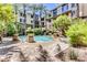 Community pool surrounded by palm trees, seating and lush landscaping at 1701 E Colter St # 491, Phoenix, AZ 85016