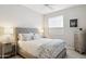Bedroom featuring neutral tones, a queen bed, bedside tables, and window providing natural light at 17850 N 68Th St # 2138, Phoenix, AZ 85054