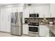 Bright kitchen featuring stainless steel appliances, white cabinets, and gray countertops with tiled backsplash at 17850 N 68Th St # 2138, Phoenix, AZ 85054