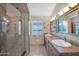 Bathroom with a large granite shower stall, dual sinks and tasteful decor at 19107 N 94Th Ave, Peoria, AZ 85382